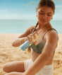 Woman applying sunscreen on a beach