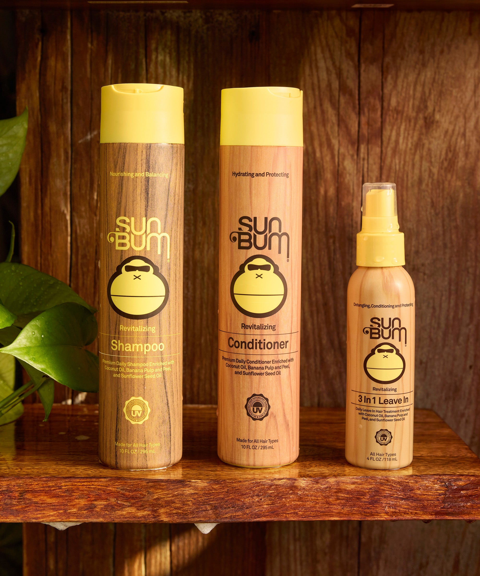 Sun Bum shampoo, conditioner, and leave-in product on a wooden shelf with a wooden background.