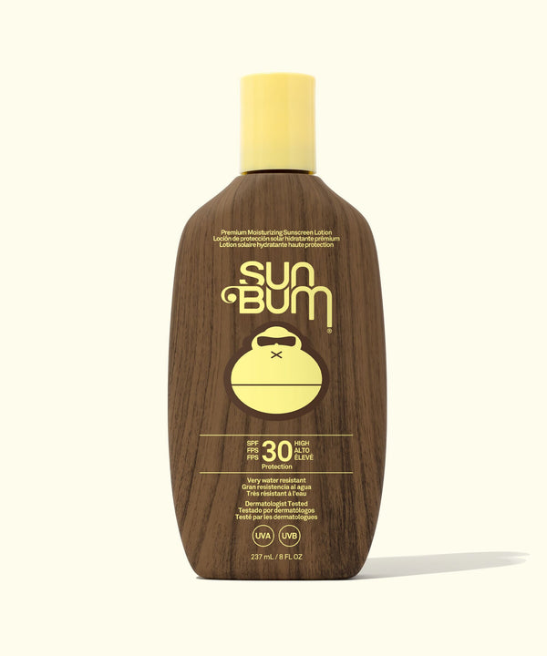 Sun Bum sunscreen bottle with wooden texture and yellow cap on a white background