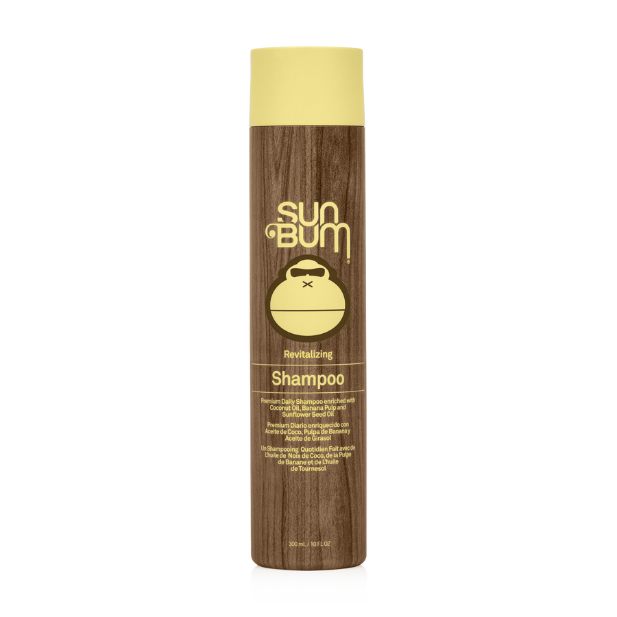 A bottle of Sun Bum Revitalizing Shampoo with a wooden cap and a label that includes the product name and the brand's logo featuring a turtle.